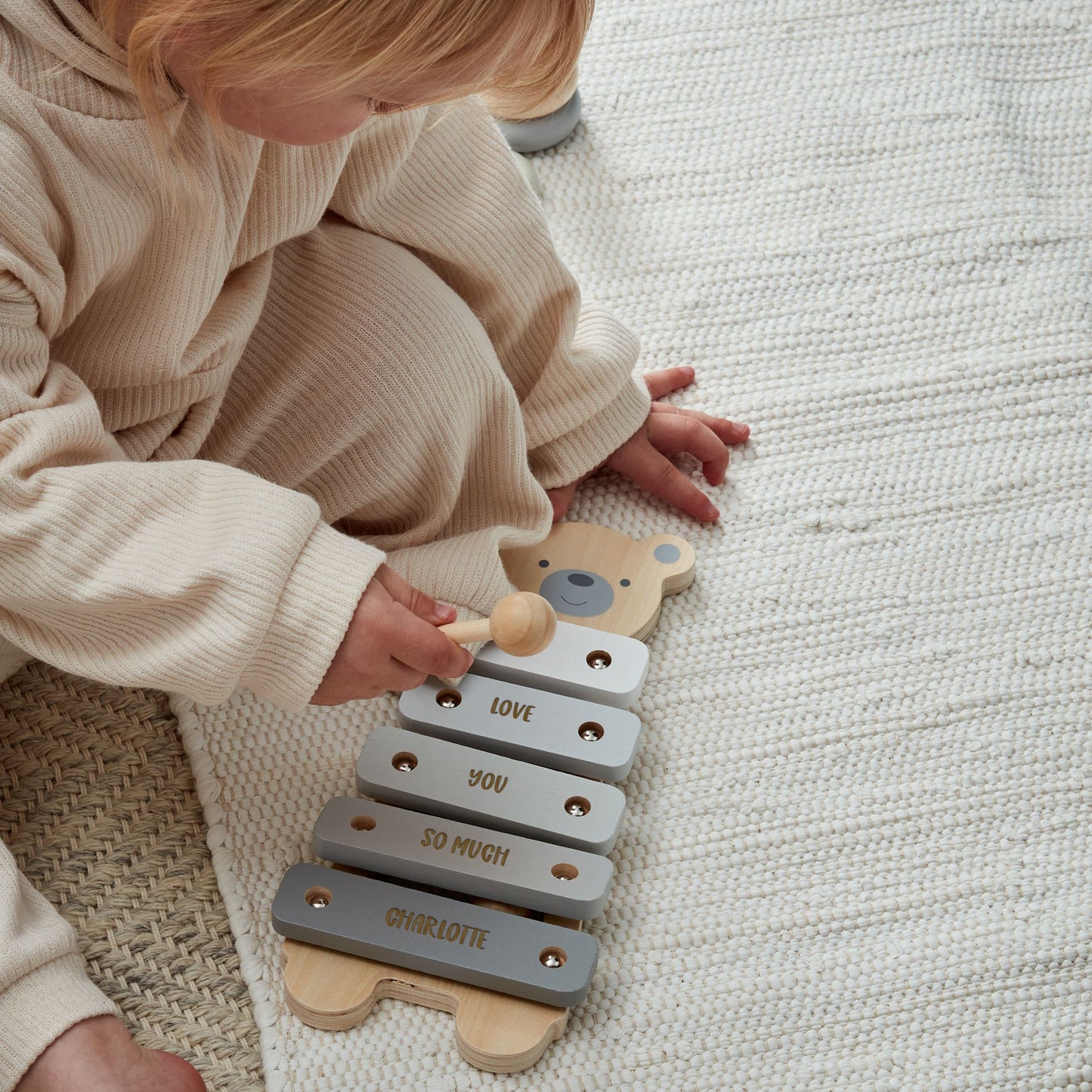 Child playing with bear xylophone music toy