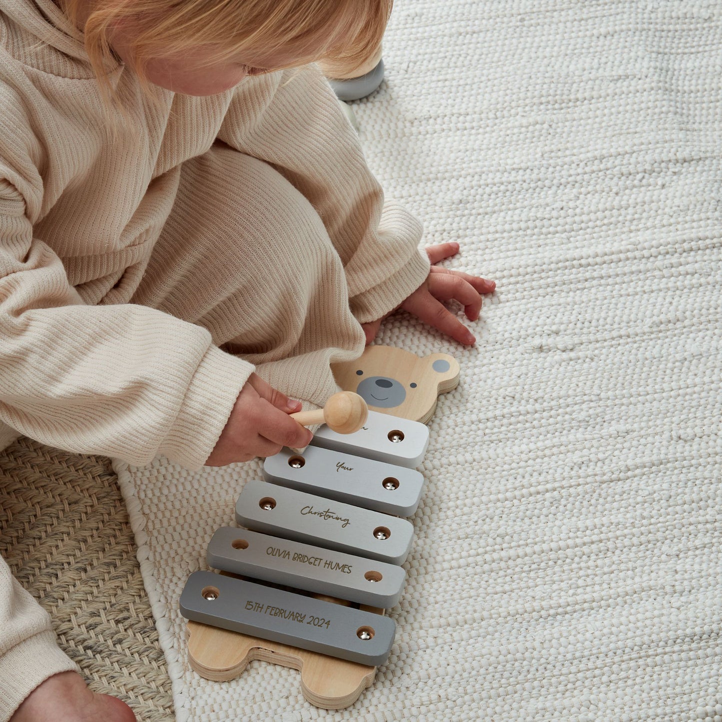 Child playing with wooden bear xylophone music toy