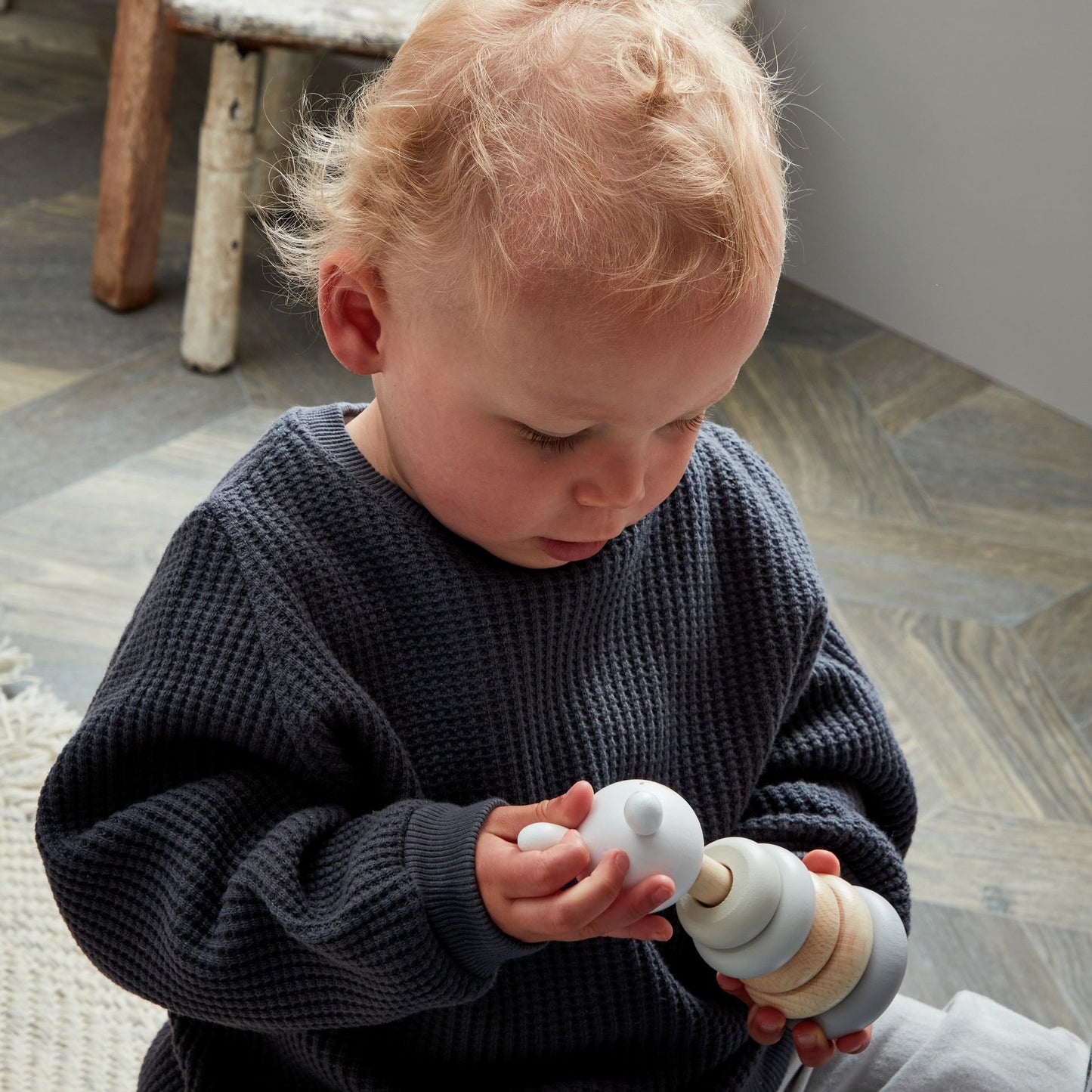 Child playing with wooden rabbit stacking toy