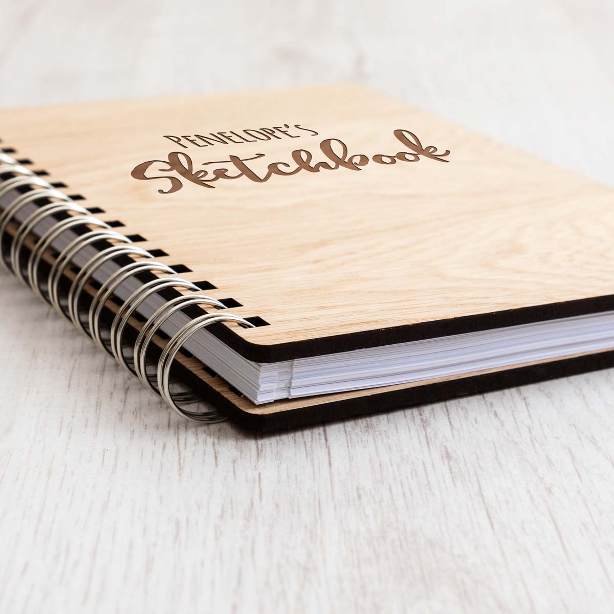 Close up of wooden sketchbook with laser-engraved personalisation