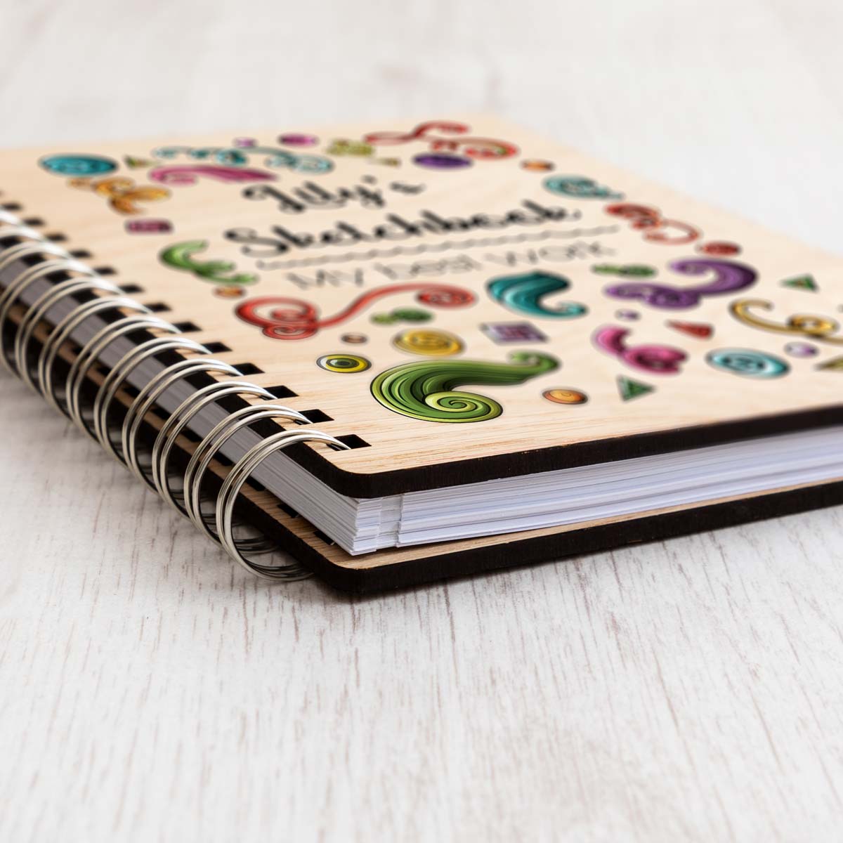 Close up of sketchbook with oak veneer covers, plain paper and ring binder