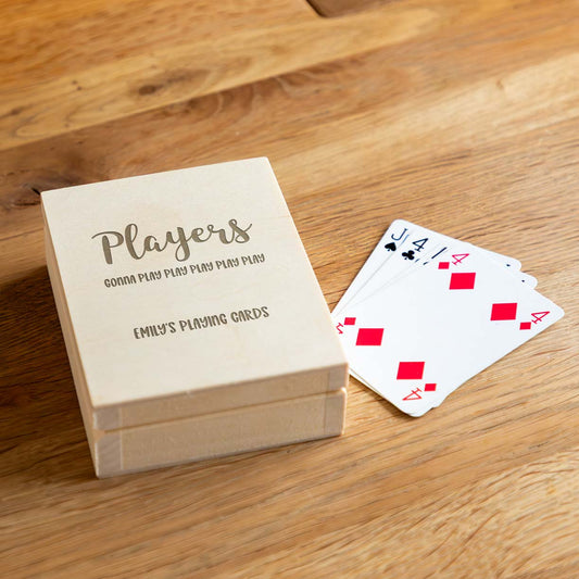Wooden playing card box engraved with 'Players gonna play play play play play' and personalised text with a deck of cards on a wooden surface.