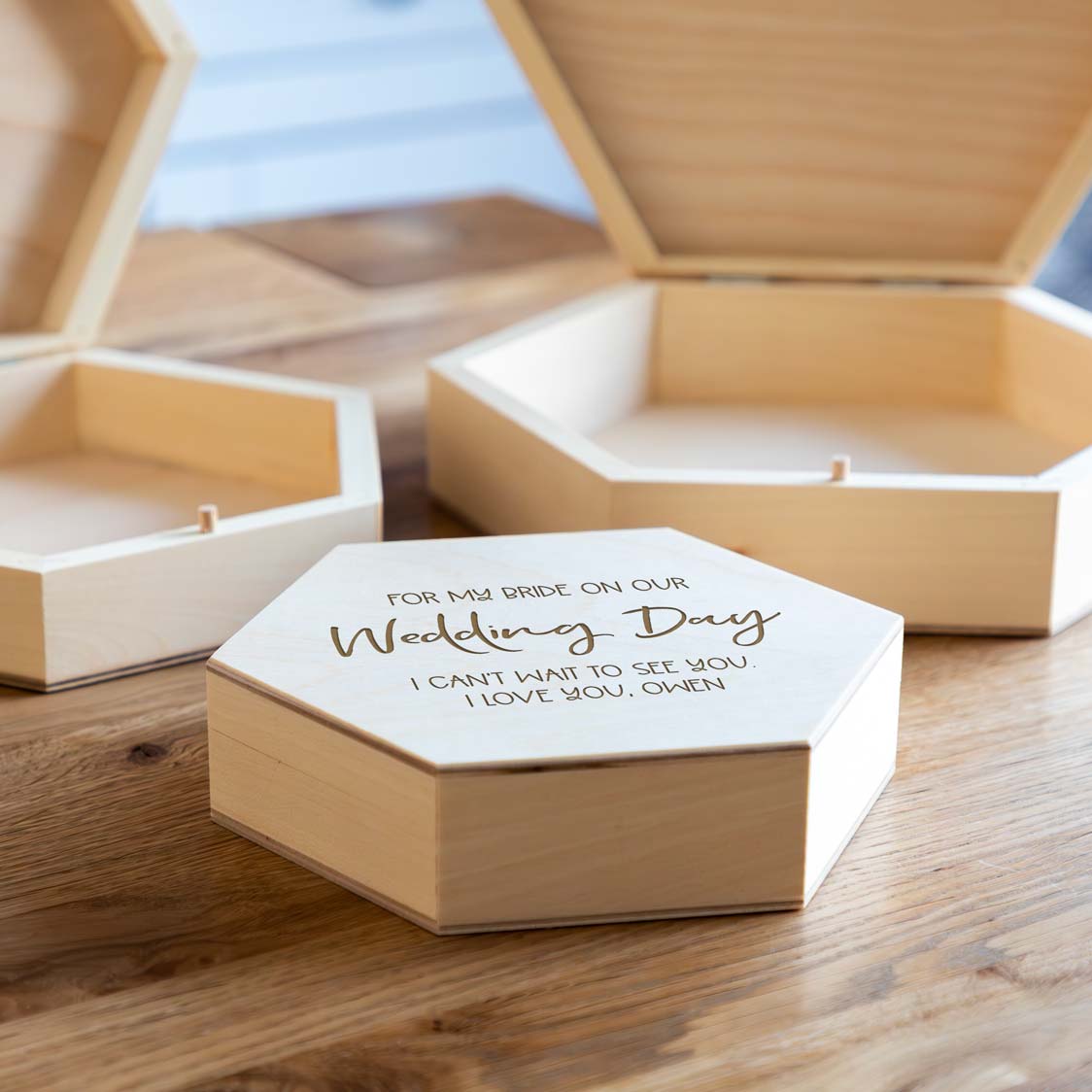 Wooden hexagonal keepsake box with engraved text 'For my bride on our wedding day' with a personalised message, on a wooden surface