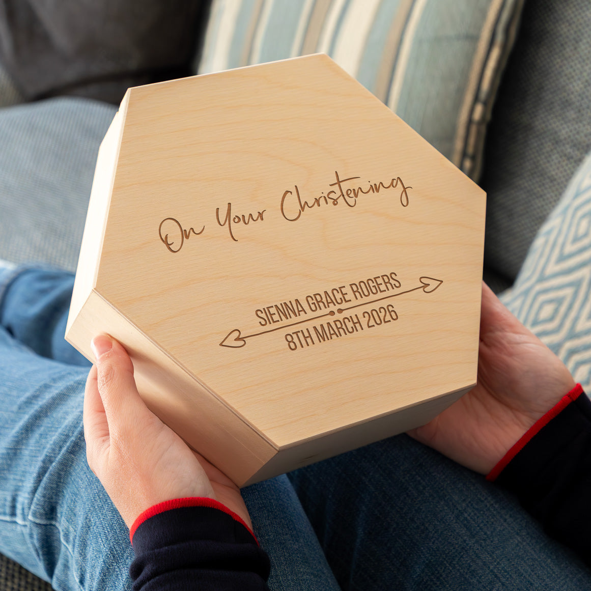 Person holding a wooden keepsake box engraved with 'On Your Christening' and personalised with a name and date.