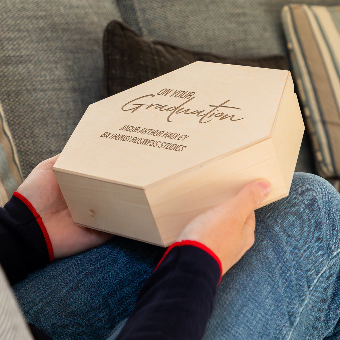 Person holding a wooden graduation keepsake box gift with engraved personalised text.