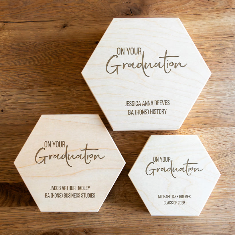 Three hexagonal wooden keepsake boxes in small, medium and large, personalised with engraved text saying 'On Your Graduation'.