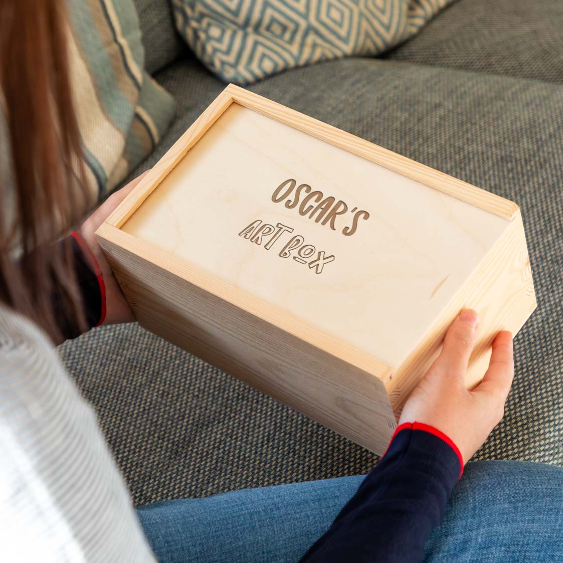 Person holding a wooden arts and crafts box engraved with the personalised name and text.