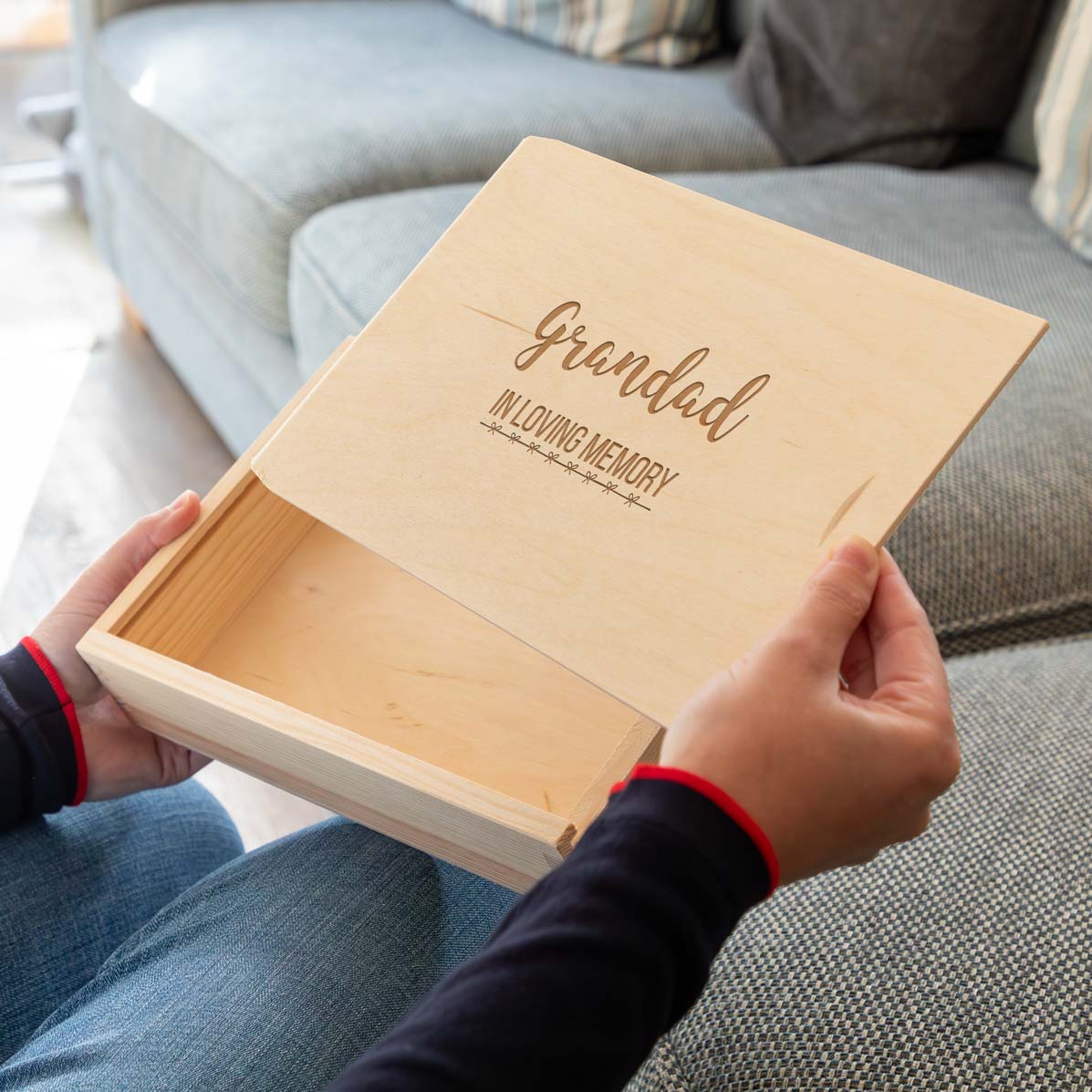 Wooden photo box with 'Grandad In Loving Memory' personalised text held by a person on a couch.