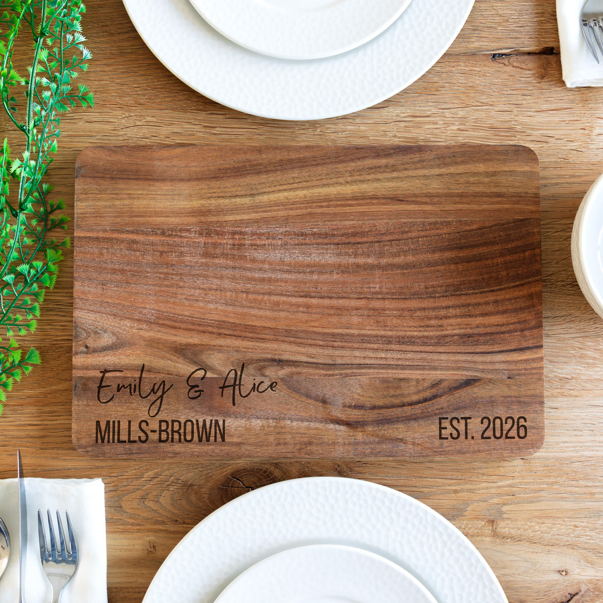 Wooden serving board with engraved personalised text on a table setting.