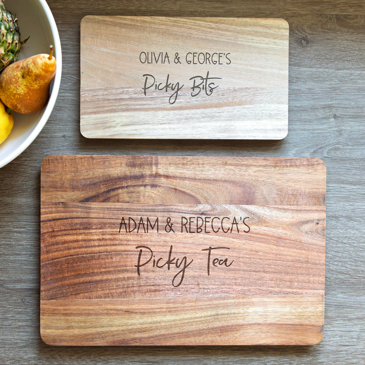 Two wooden serving boards in small and large sizes with engraved text on a wooden surface.