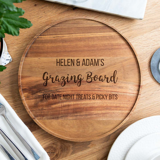 Wooden grazing board with engraved personalised text on a wooden surface.
