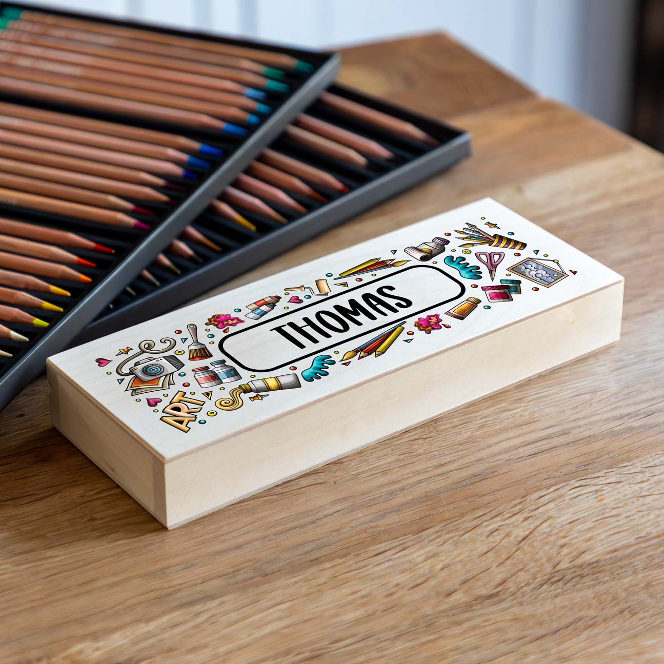 Wooden pencil case with colourful artist illustrations and a personalised name.