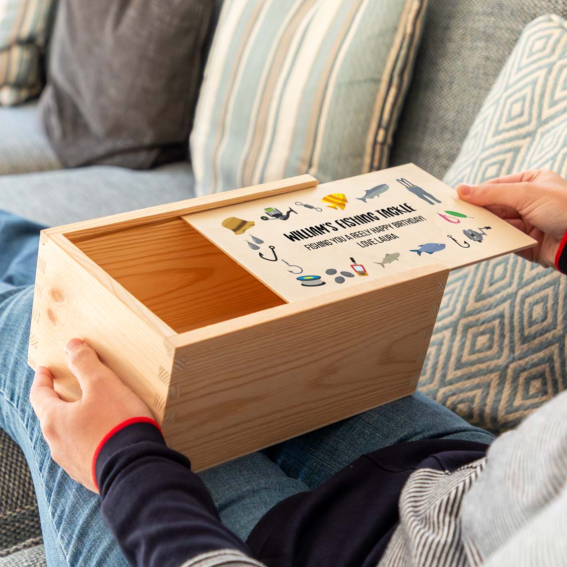 Wooden fishing tackle box with a sliding lid featuring fishing illustrations and personalised text.