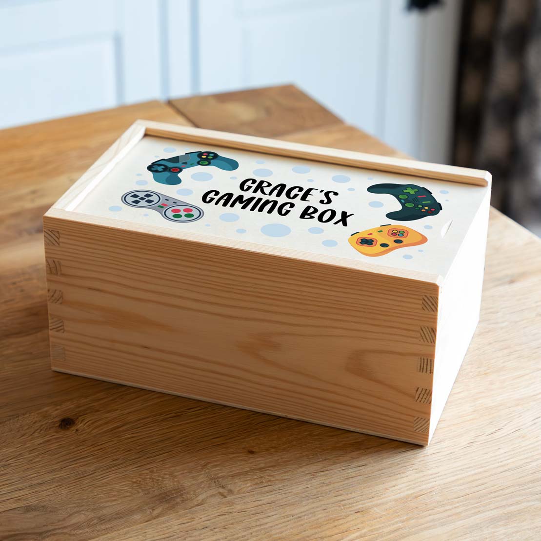 Wooden gaming box with personalised design on a wooden surface.