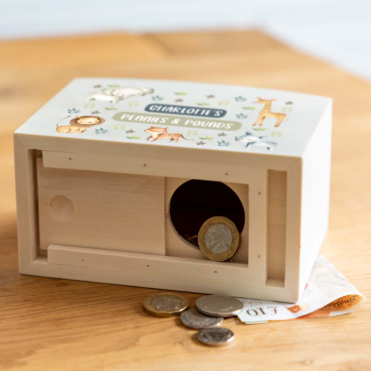 Wooden money box with a sliding opening on the bottom to access the money inside.