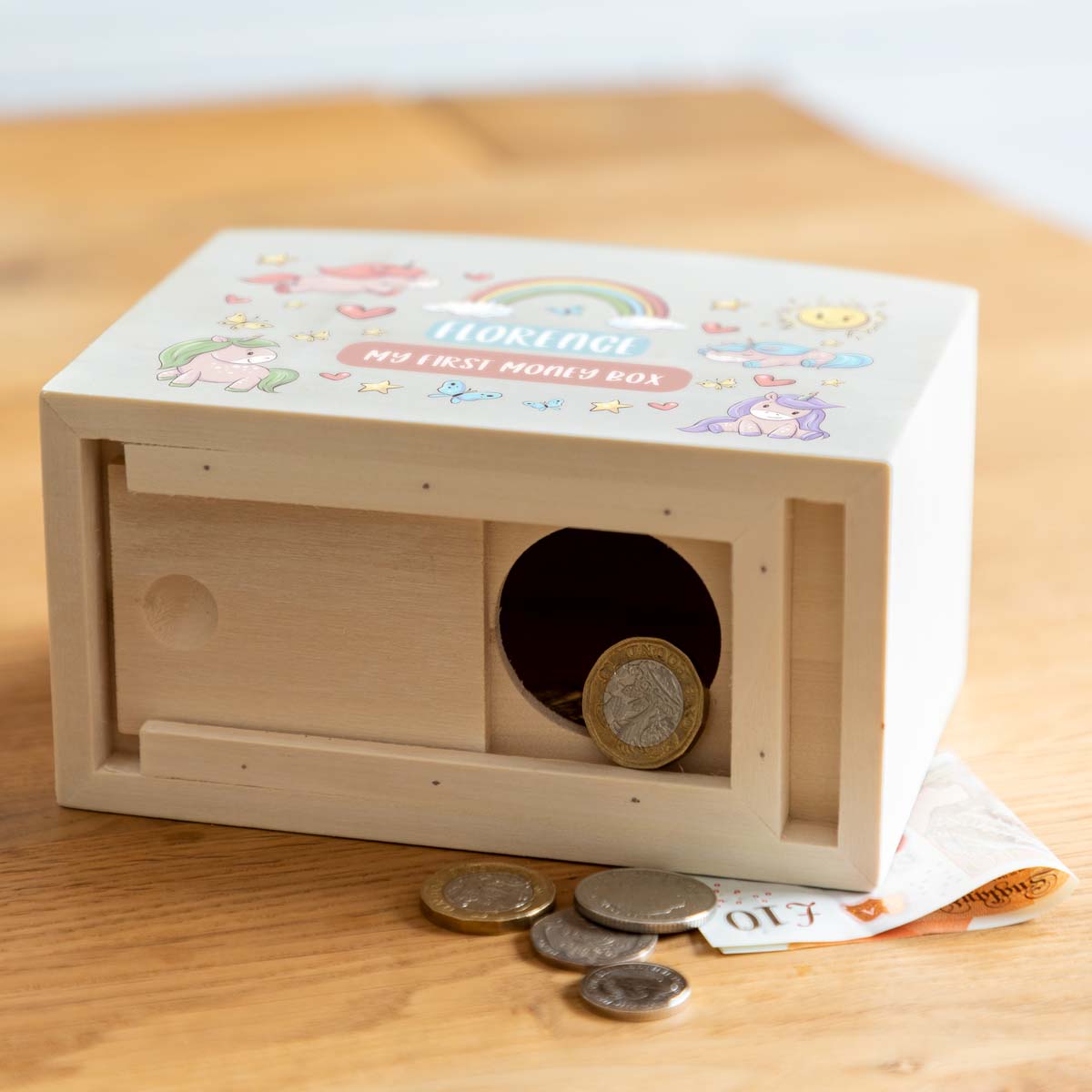 Wooden piggy bank with a sliding opening on the bottom to access the money.