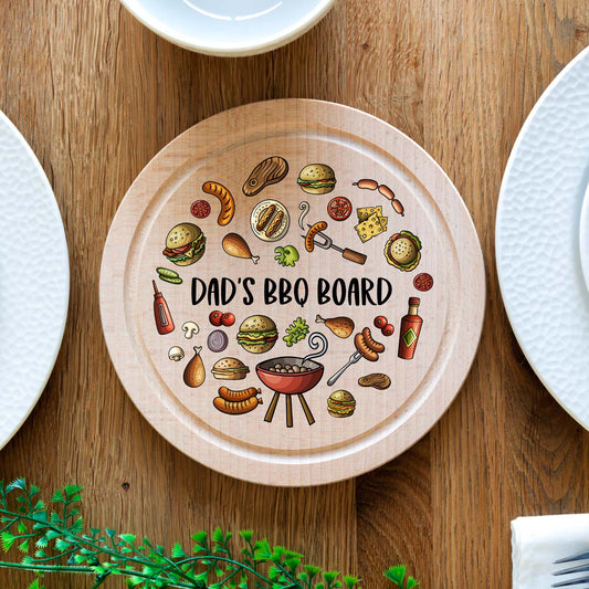 Wooden serving board with BBQ-themed illustrations and 'Dad's BBQ Board' personalised text on a wooden table.