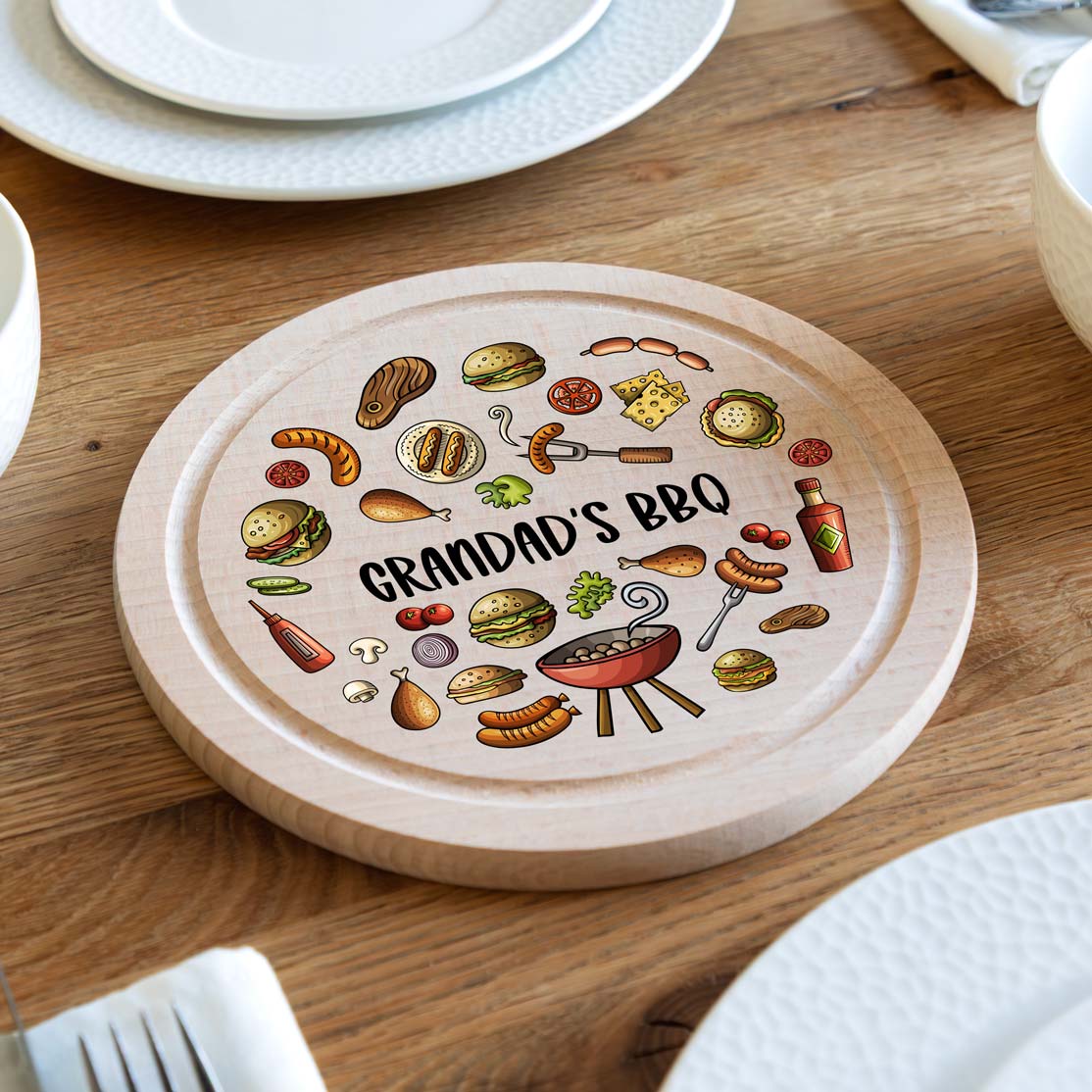 Round wooden serving board with 'Grandad's BBQ' personalised design on a wooden table.