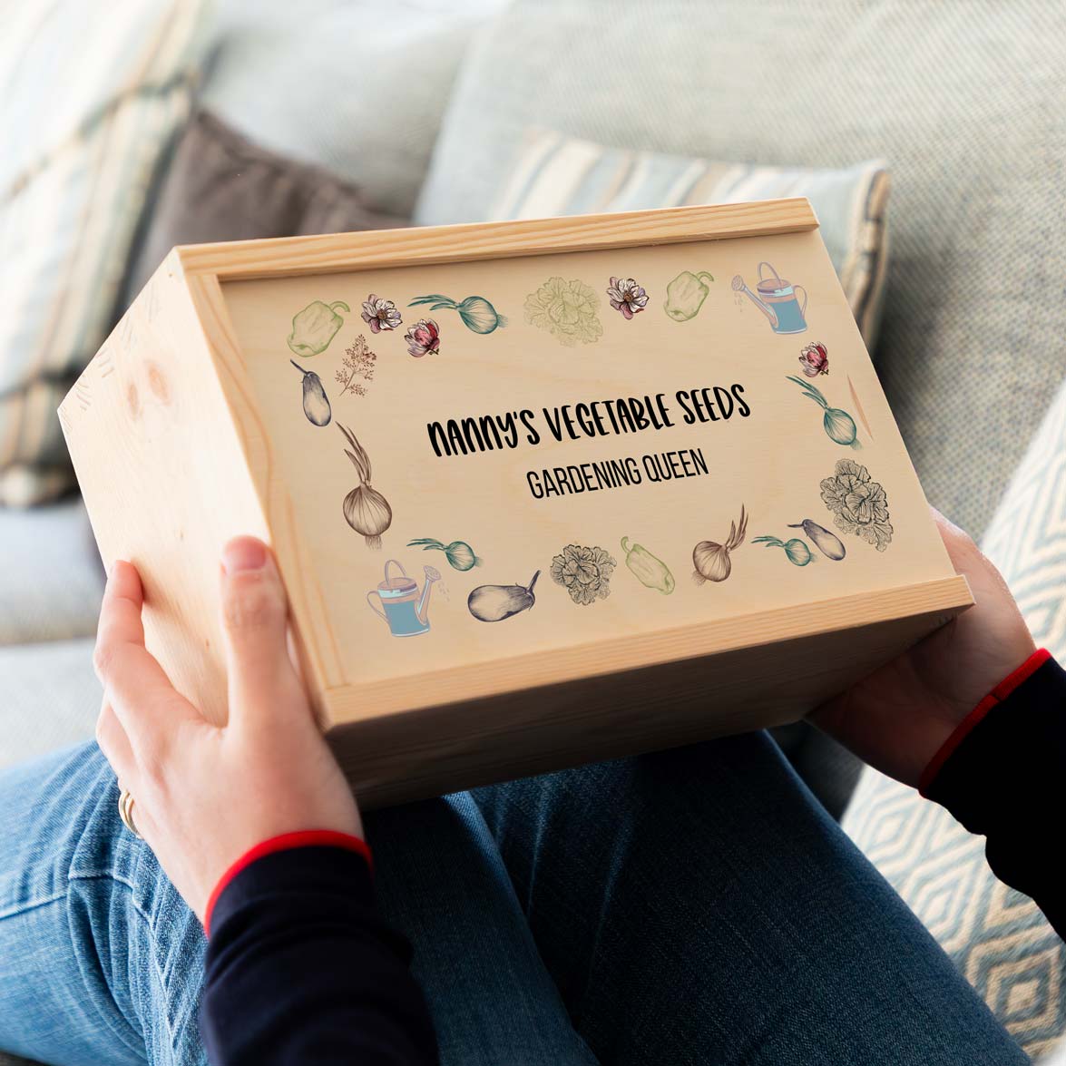 Person holding a wooden box with personalised text saying 'Nanny's Vegetable Seeds Gardening Queen' with vegetable illustrations.