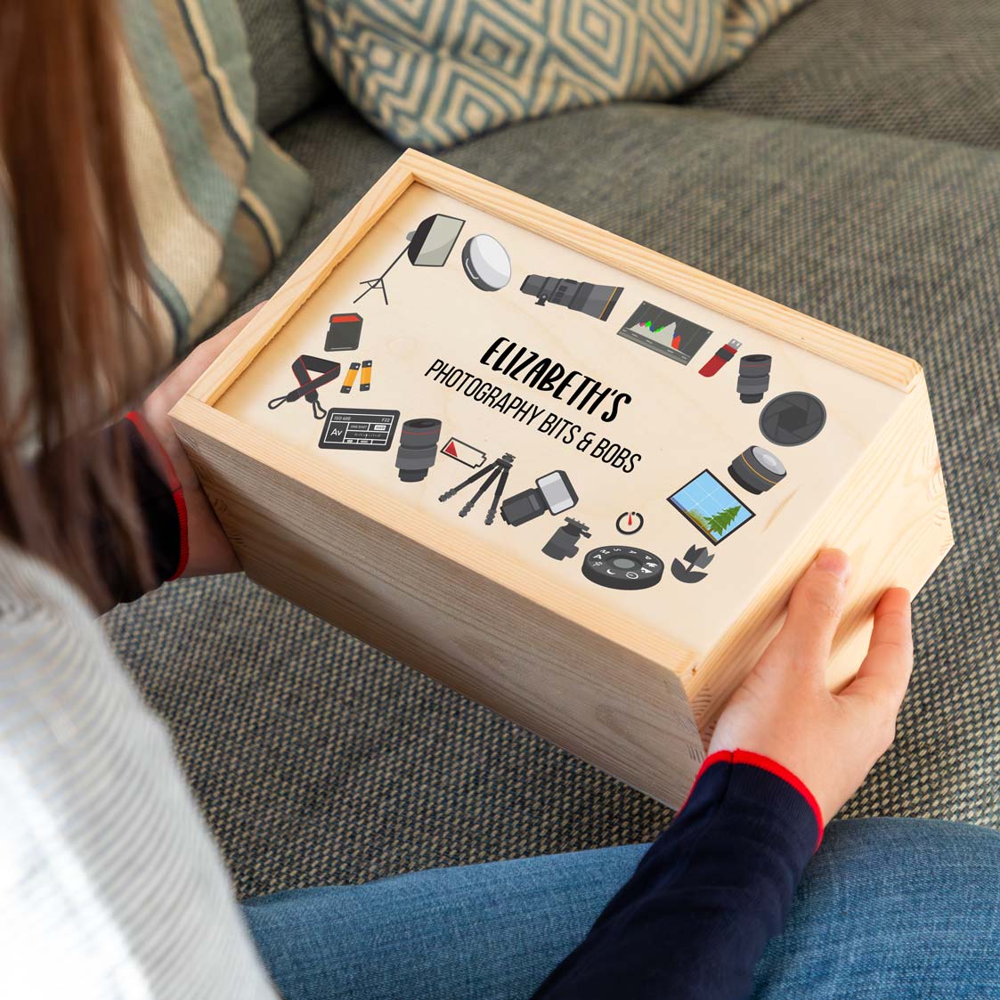 Person holding a wooden storage box labeled 'Photography Bits & Bobs' with personalised text.