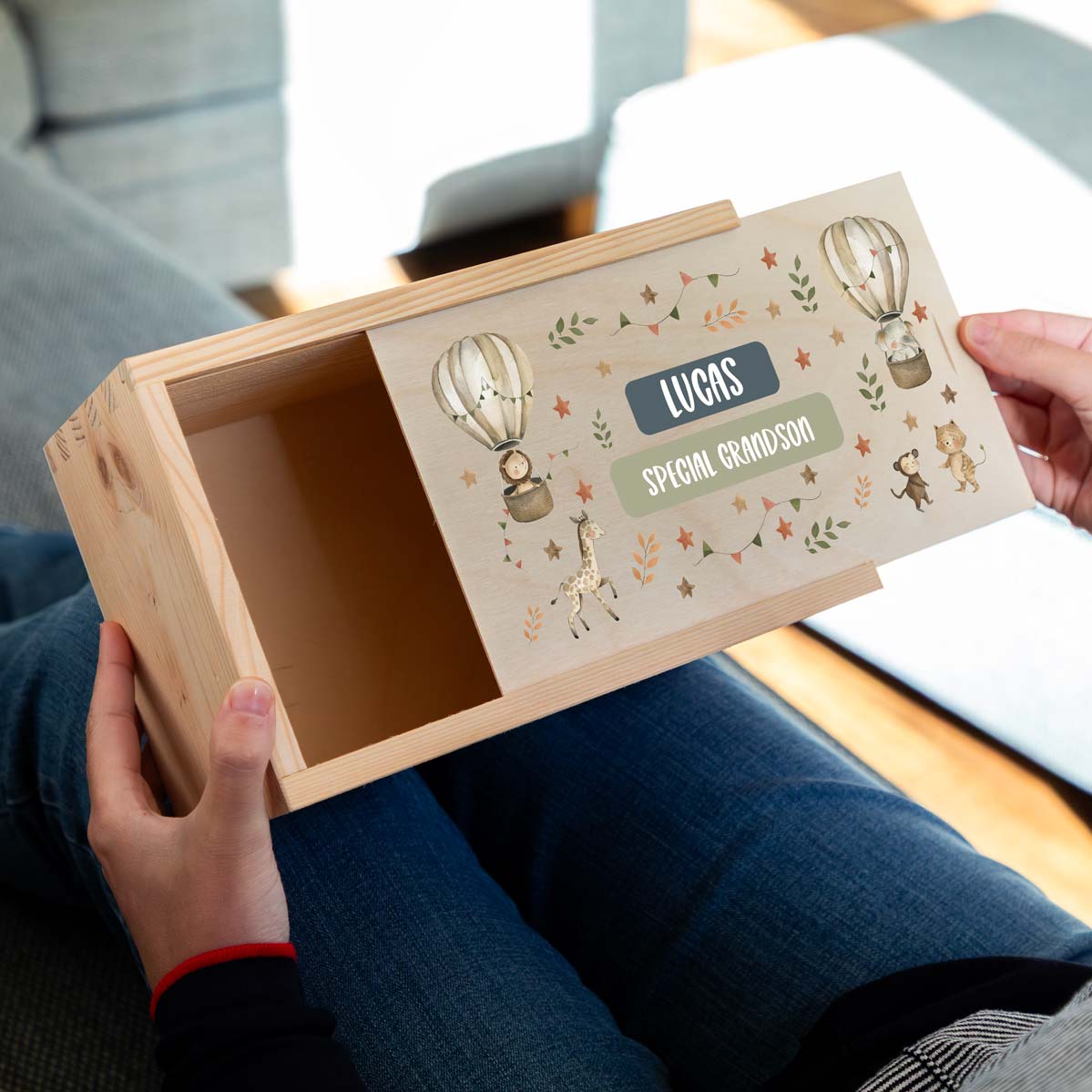 Wooden keepsake box with a safari animal design held by a person, featuring the personalised name and the title 'Special Grandson'.